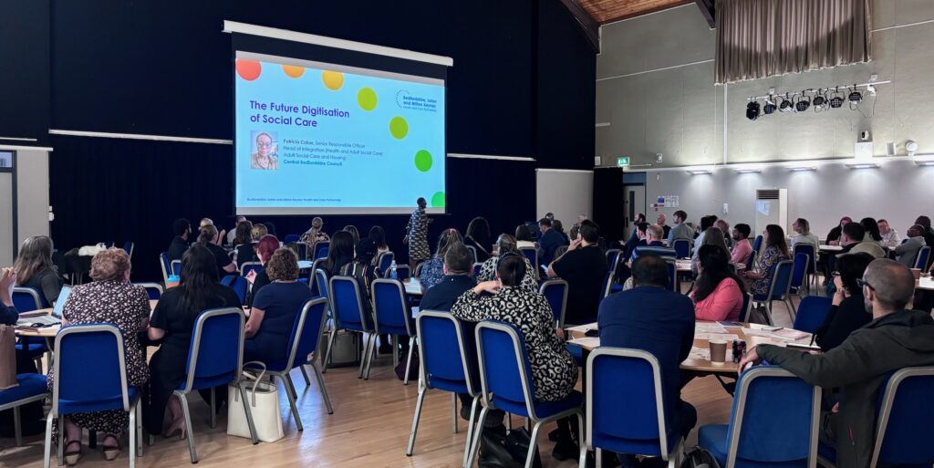 Lots of care providers watching a presentation at the BLMK Care Conference