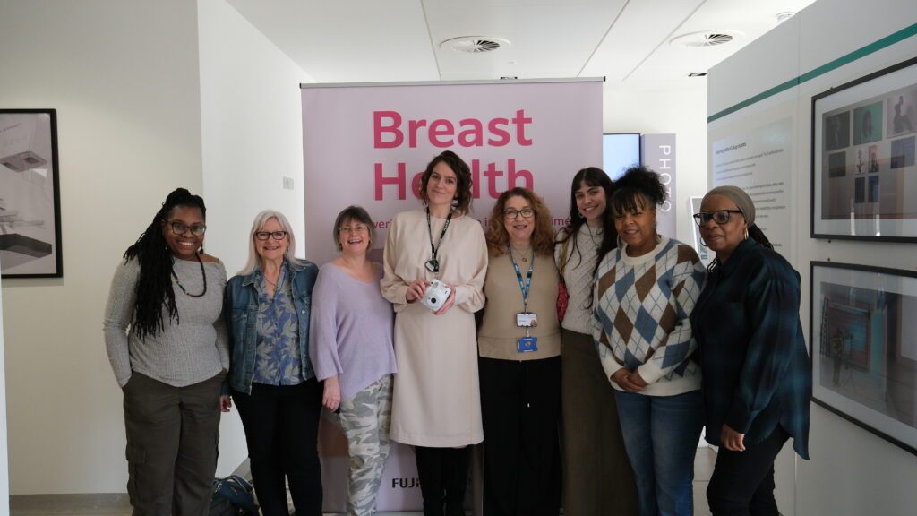 A group of women standing in front of a banner marked 'Breast Health'.